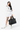 Model holding the Sherpani Boston AT in Carbon in her left hand. #color_carbon