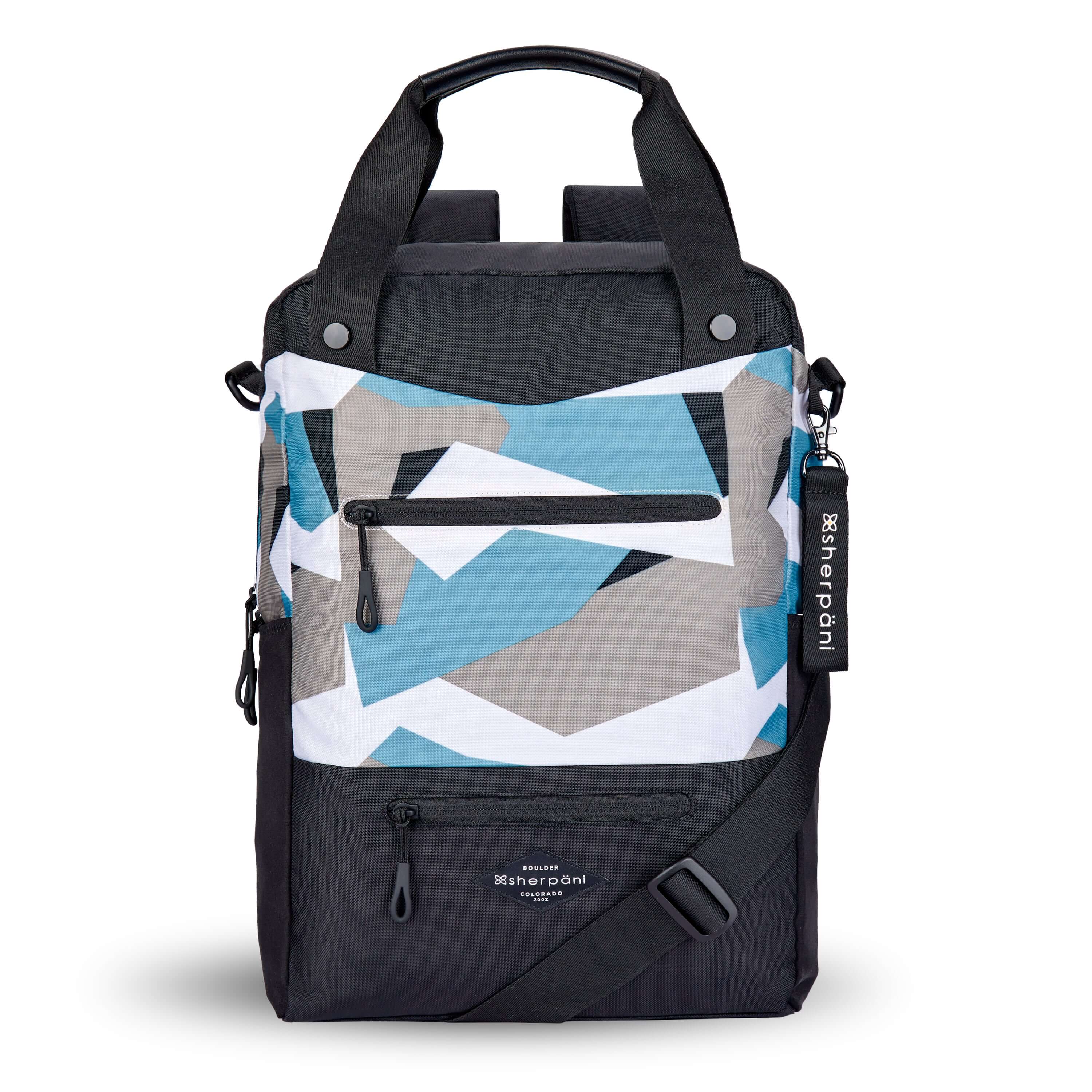 Flat front view of Sherpani's three in one bag, the Camden in Summer Camo. The bag is two toned in black and in a camouflage pattern of blue, grey and white. There are two external zipper pockets on the front panel with easy pull zippers in black. A branded Sherpani keychain is clipped to the upper right corner. An water bottle holder sits on either side of the bag. The bag has an adjustable crossbody strap, padded/adjustable backpack straps and short tote handles fixed at the top. 
