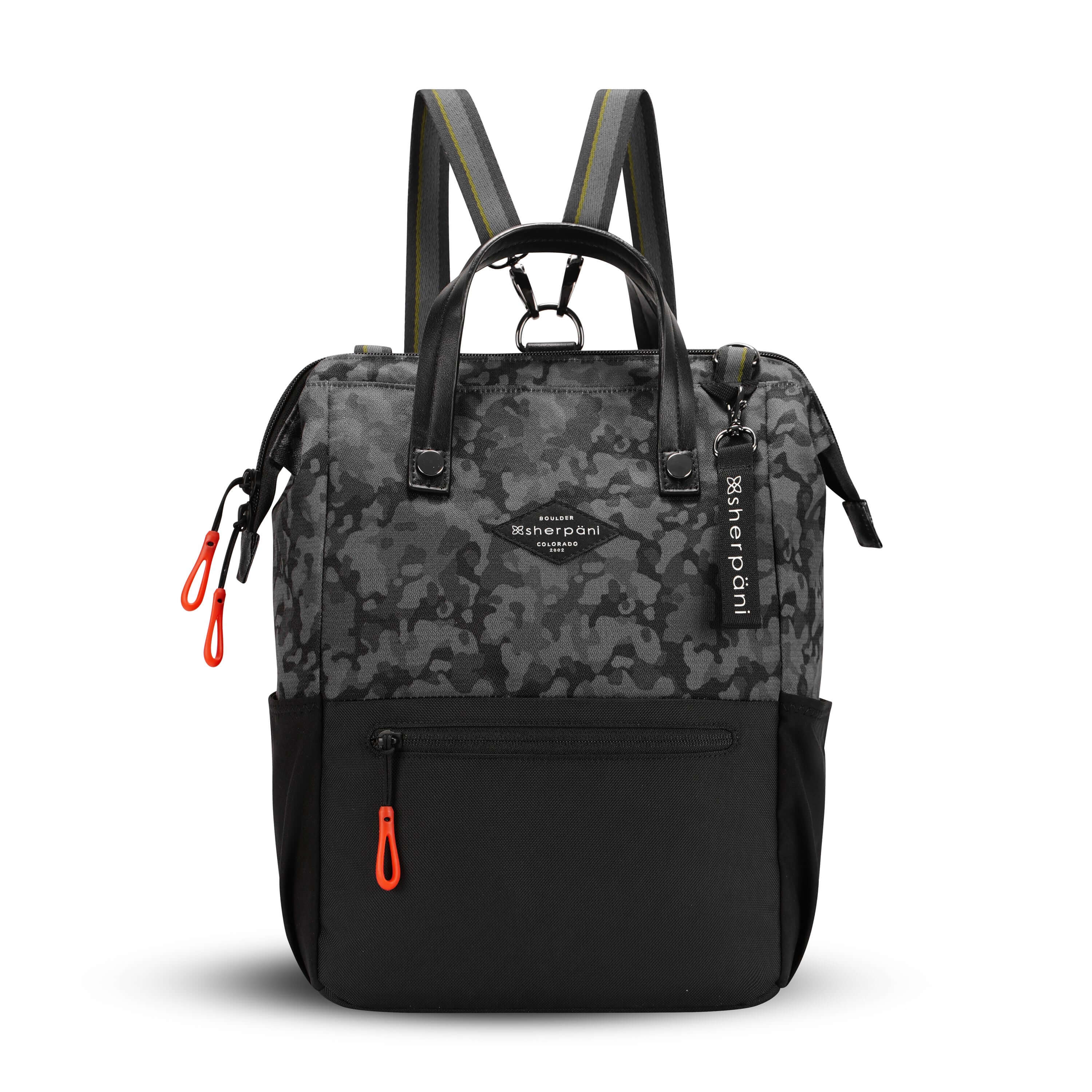Flat front view of Sherpani three in one bag, the Dispatch in Dream Camo. The bag is two toned: the top is a camouflage pattern of black and gray, and the bottom is black. There is an external zipper pocket on the front panel. Easy pull zippers are accented in red. A branded Sherpani keychain is clipped to the upper right corner. Elastic water bottle holders sit on either side of the bag. It has short tote handles and adjustable straps that can function for a backpack or crossbody. 