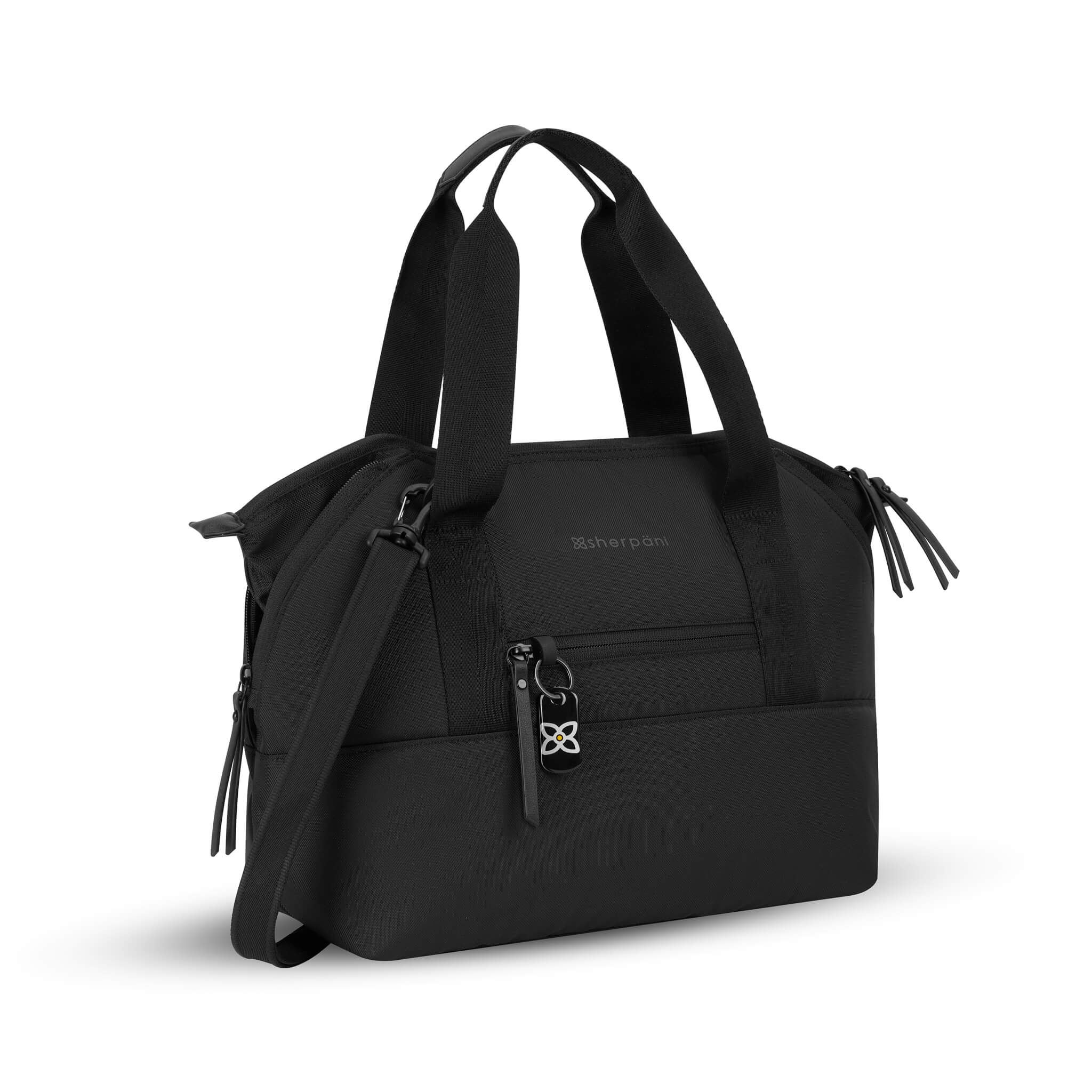 Front angled view of the Eclipse in Carbon (classic black). This travel tote features a zipper pocket in each corner which makes the Eclipse an expandable bag. This Anti-Theft purse is sustainably made from recycled materials including post consumer plastic and vegan leather. 