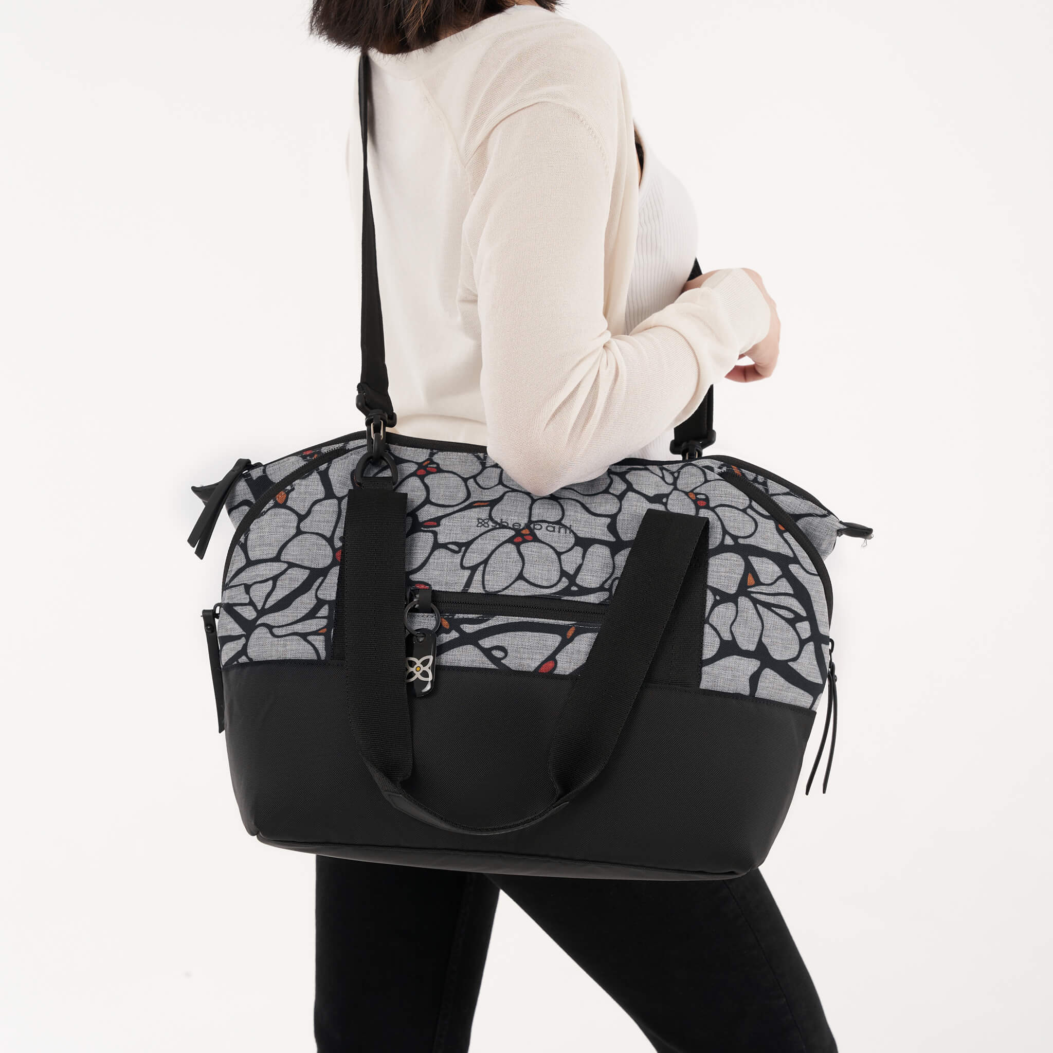 A model using the detachable strap to wear the Eclipse in Sakura as a crossbody travel purse. 