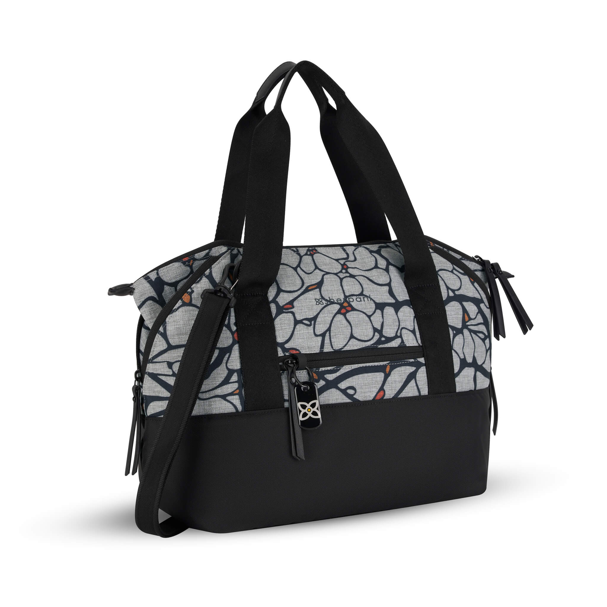 Front angled view of the Eclipse in Sakura. This travel tote features a zipper pocket in each corner which makes the Eclipse an expandable bag. This Anti-Theft purse is sustainably made from recycled materials including post consumer plastic and vegan leather. 