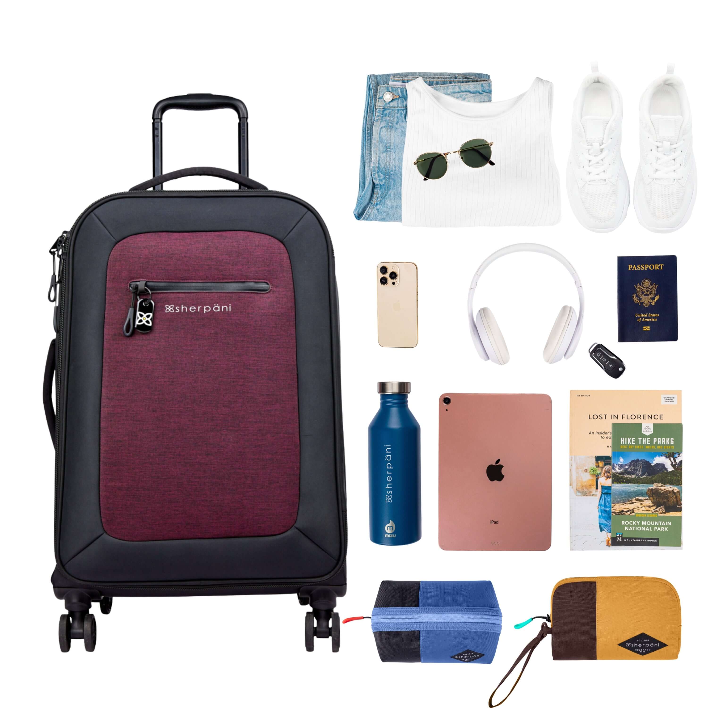 Top view of example items to fill the suitcase. On the left lies Sherpani’s Anti-Theft luggage, the Hemisphere in Merlot. On the right lies an assortment of items: change of clothes, sunglasses, sneakers, phone, headphones, car key, passport, water bottle, tablet, travel books, Sherpani travel accessories, the Harmony in Pacific Blue and the Jolie in Sundial. 