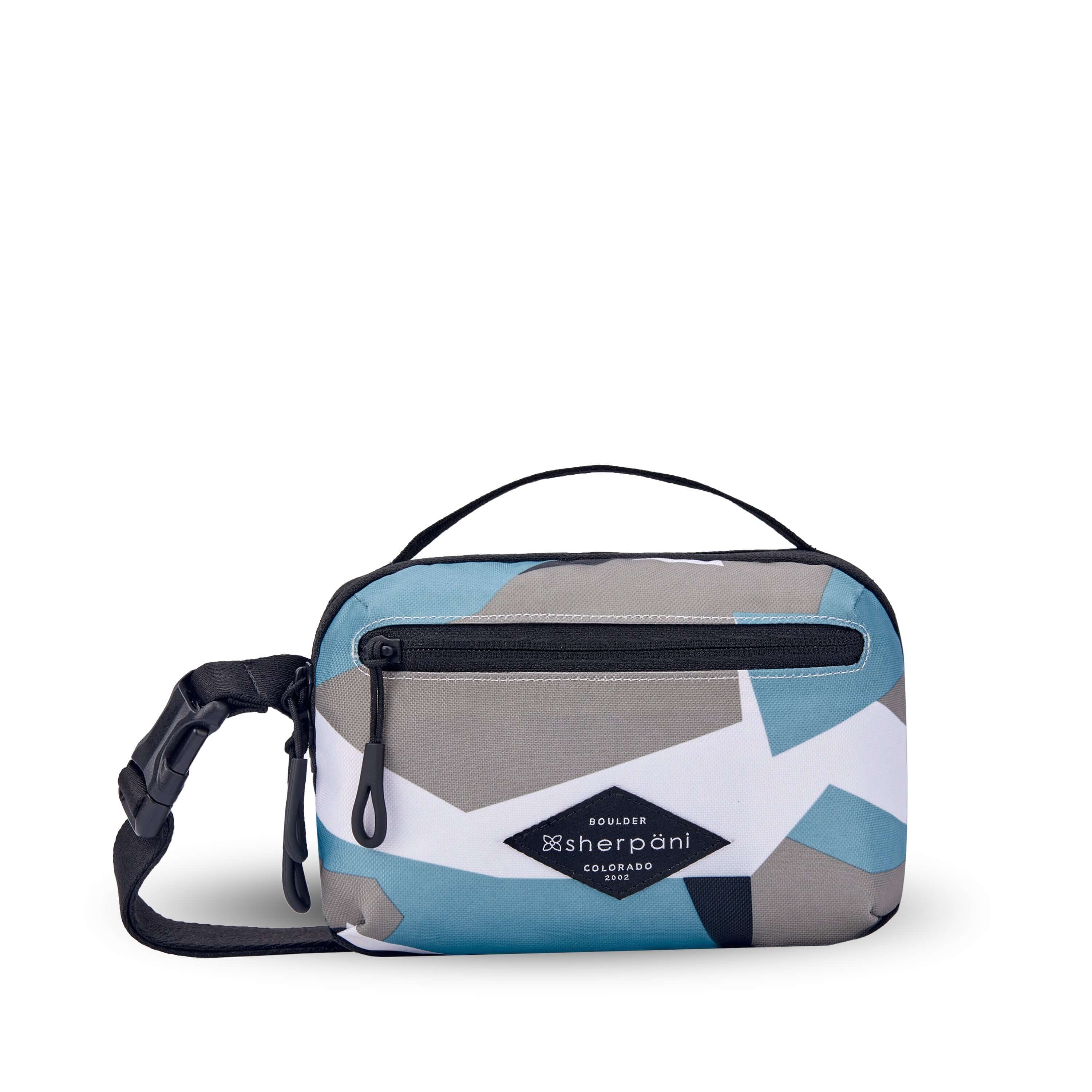 Flat front view of Sherpani’s fanny pack, the Hyk in Summe Camo. The bag is two toned, the front half is a camouflage pattern of light blue, white and gray, and the back half is black. There is an external zipper pocket on the front of the bag. Easy pull zippers are accented in black. The fanny pack features an adjustable strap with a buckle. 