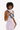 Close-up of a model wearing the Sherpani's fanny pack, the Hyk in Magnolia, as a crossbody #color_magnolia