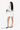 A model holds the Sherpani travel accessory, the Jolie in Con Leche at her waistband. #color_con-leche
