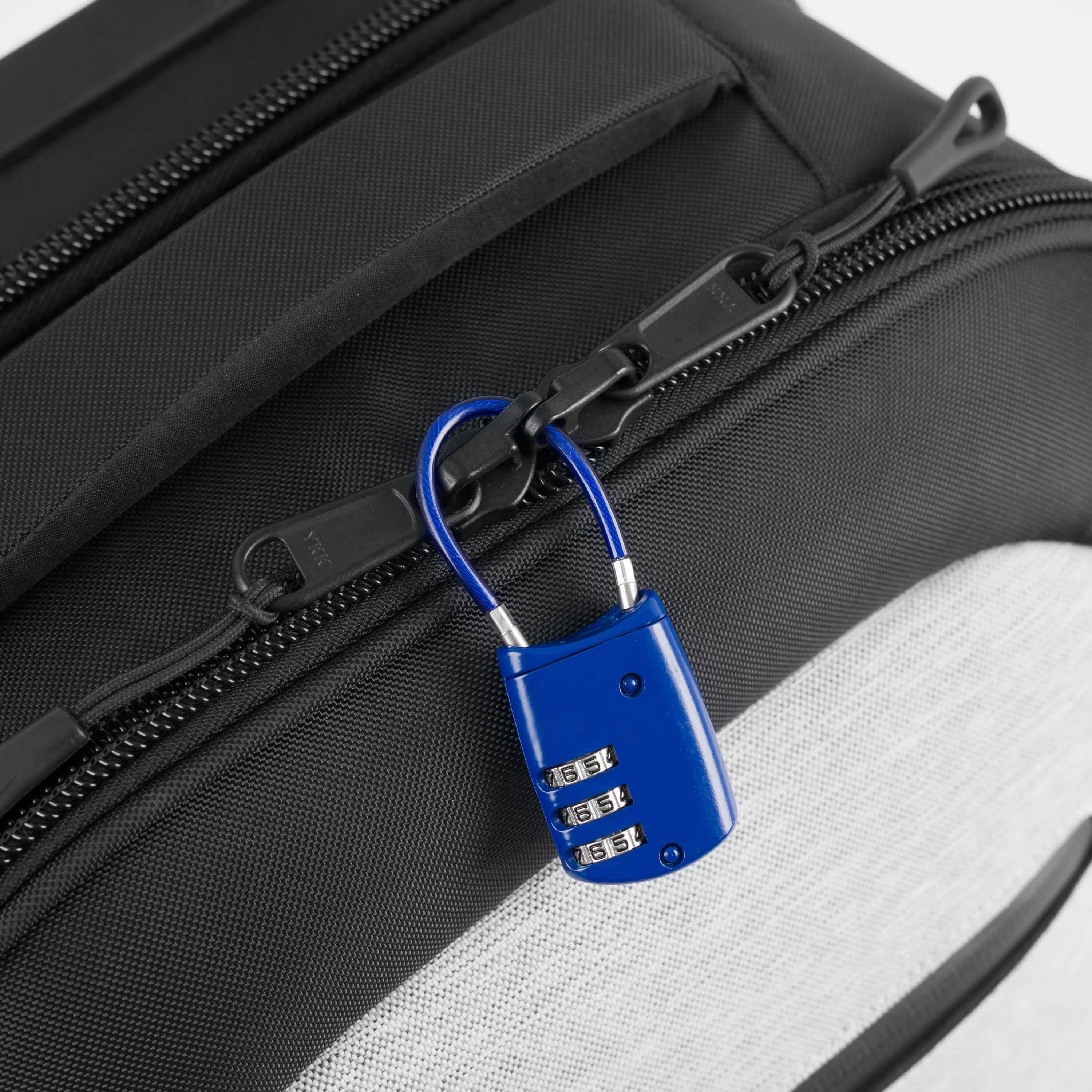 Close up view of a lock securing together the two zippers that create the main compartment of Sherpani's Anti-Theft luggage the Latitude in Sterling. 