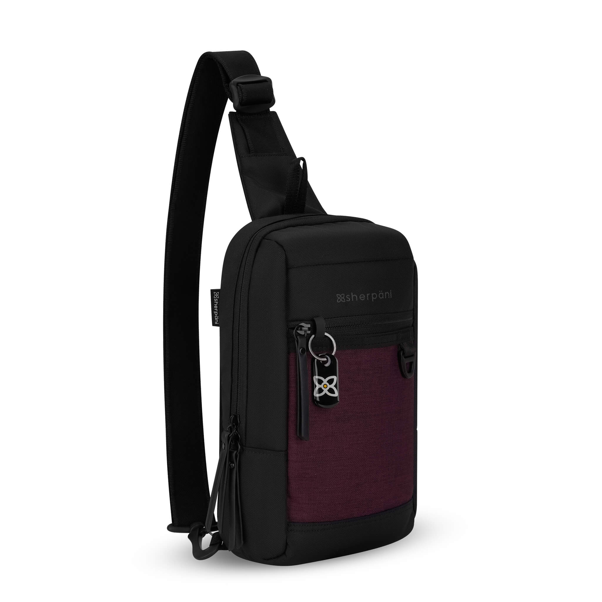 Angled front view of Sherpani mini sling backpack, the Metro in Merlot. This Anti-Theft sling includes security features for safe travels and an adjustable crossbody strap that can convert the Metro to a left-handed design. 
