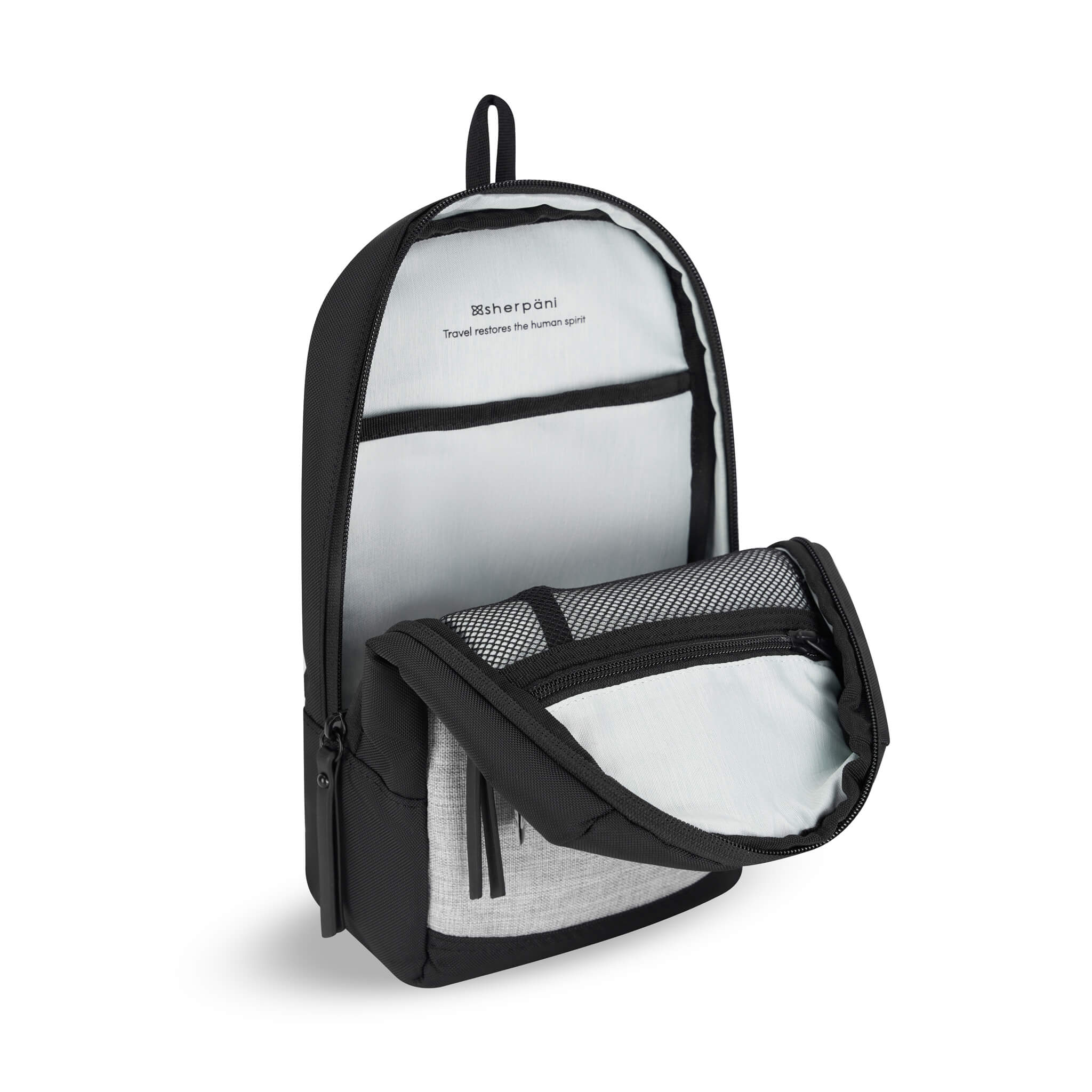 Inside view of Sherpani travel sling bag, the Metro. "Travel restores the human spirit" is printed on a light-colored interior. Features include zipper pockets made from see-through mesh for visibility. 