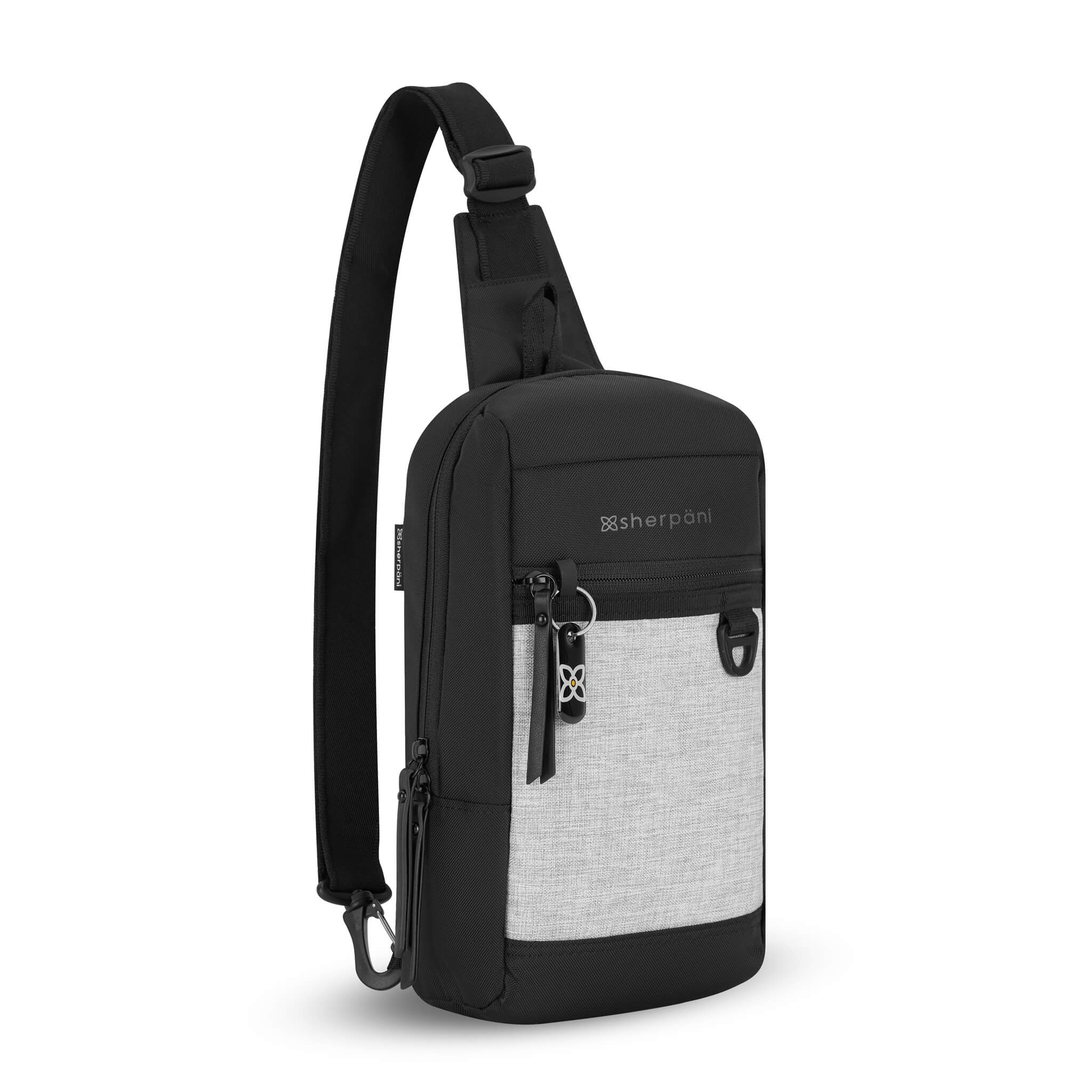Angled front view of Sherpani mini sling backpack, the Metro in Sterling. This Anti-Theft sling includes security features for safe travels and an adjustable crossbody strap that can convert the Metro to a left-handed design. 