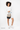 Model holding the Sherpani crossbody, the Sadie in Con Leche. #color_con-leche