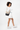 Model turned slightly to the side, wearing the Sherpani crossbody, the Sadie in Con Leche. #color_con-leche