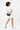 Model smiling over her right shouder, wearing the Sherpani crossbody, the Sadie in Con Leche. #color_con-leche