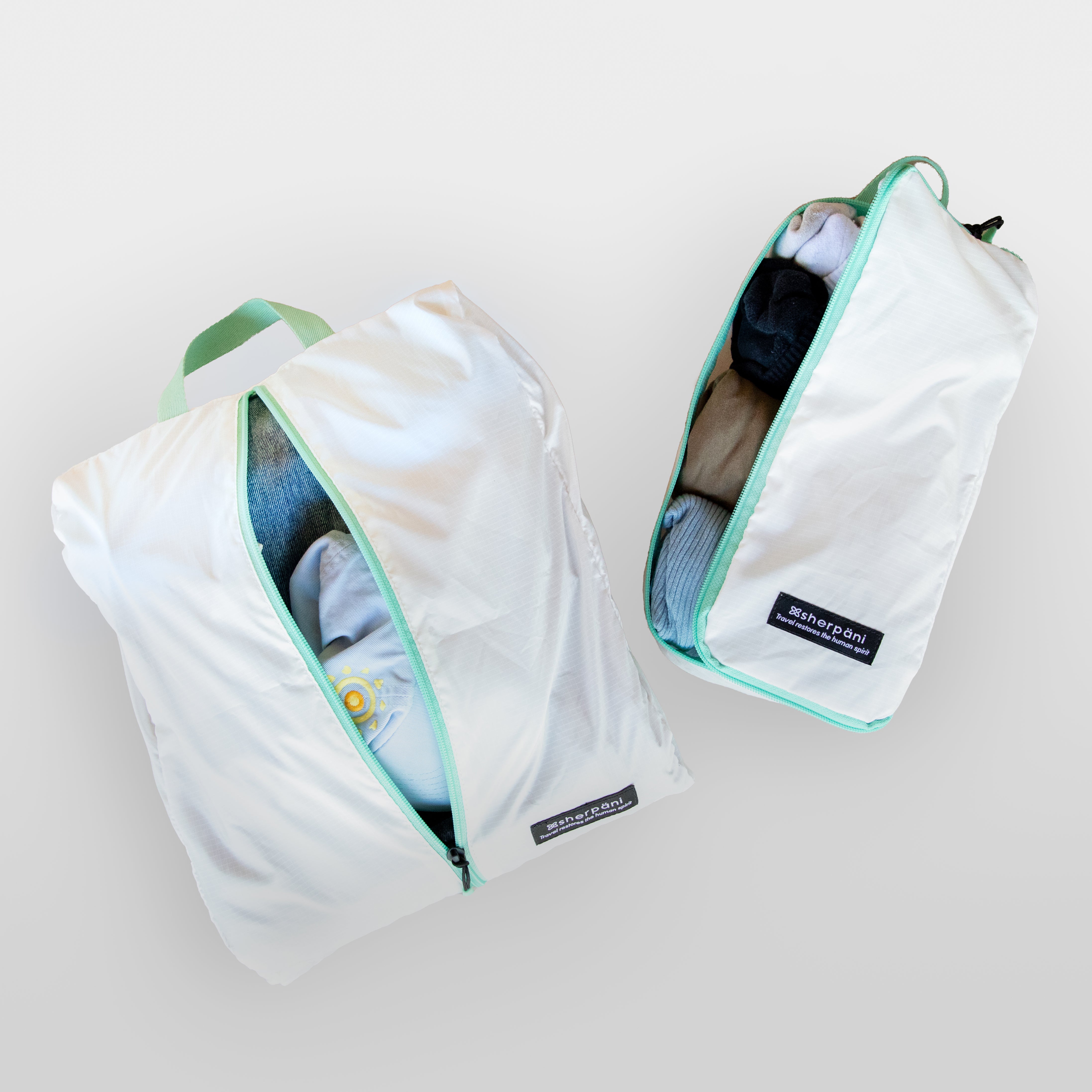Close up view of two Sherpani Packing Cubes for organized packing. 
