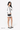 Model turned slightly to the side, wearing  Sherpani purse, the Skye in Con Leche, as a shoulder bag. #color_con-leche