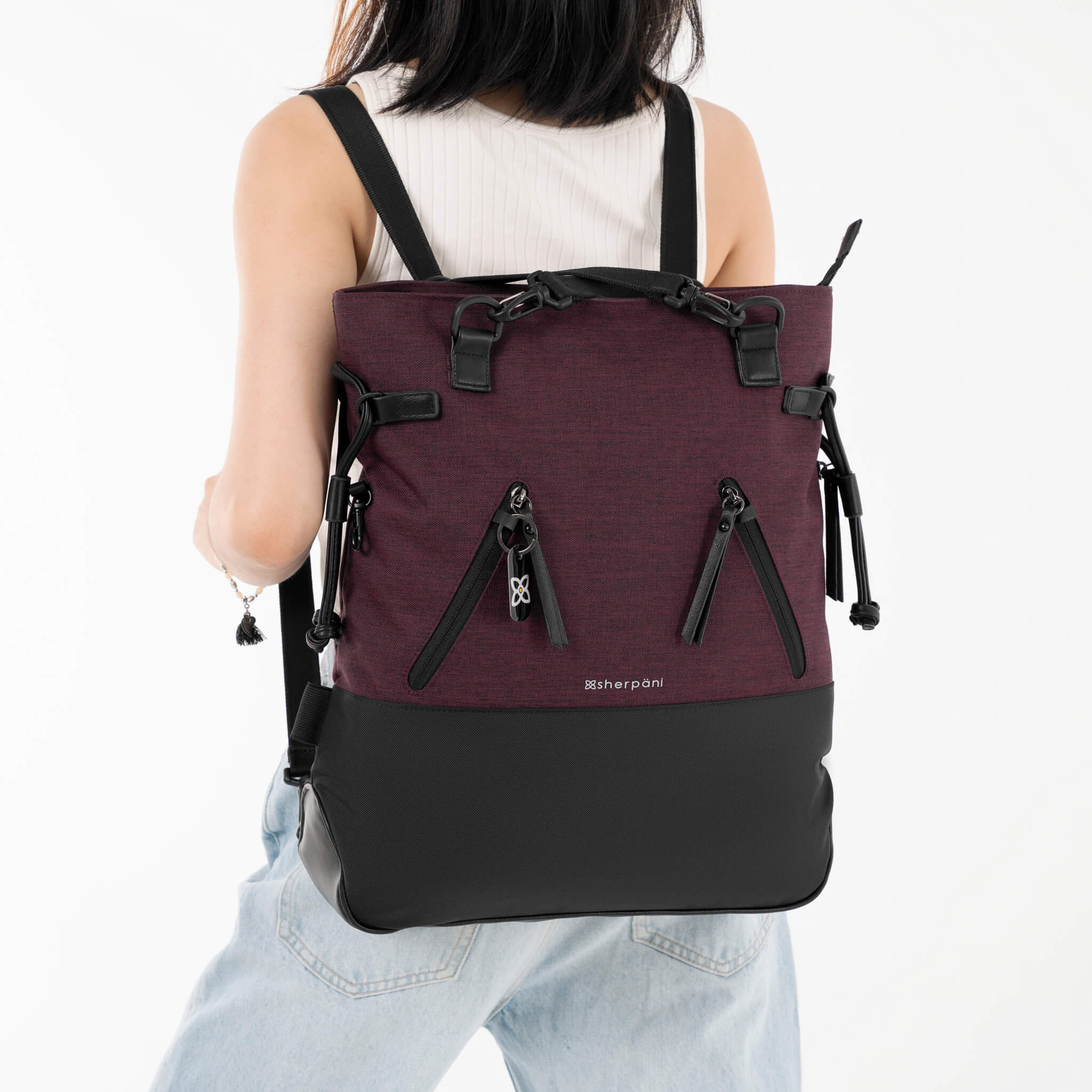 A model showing the backpack-to-tote convertible design, the Tempest in Merlot, by Sherpani. 