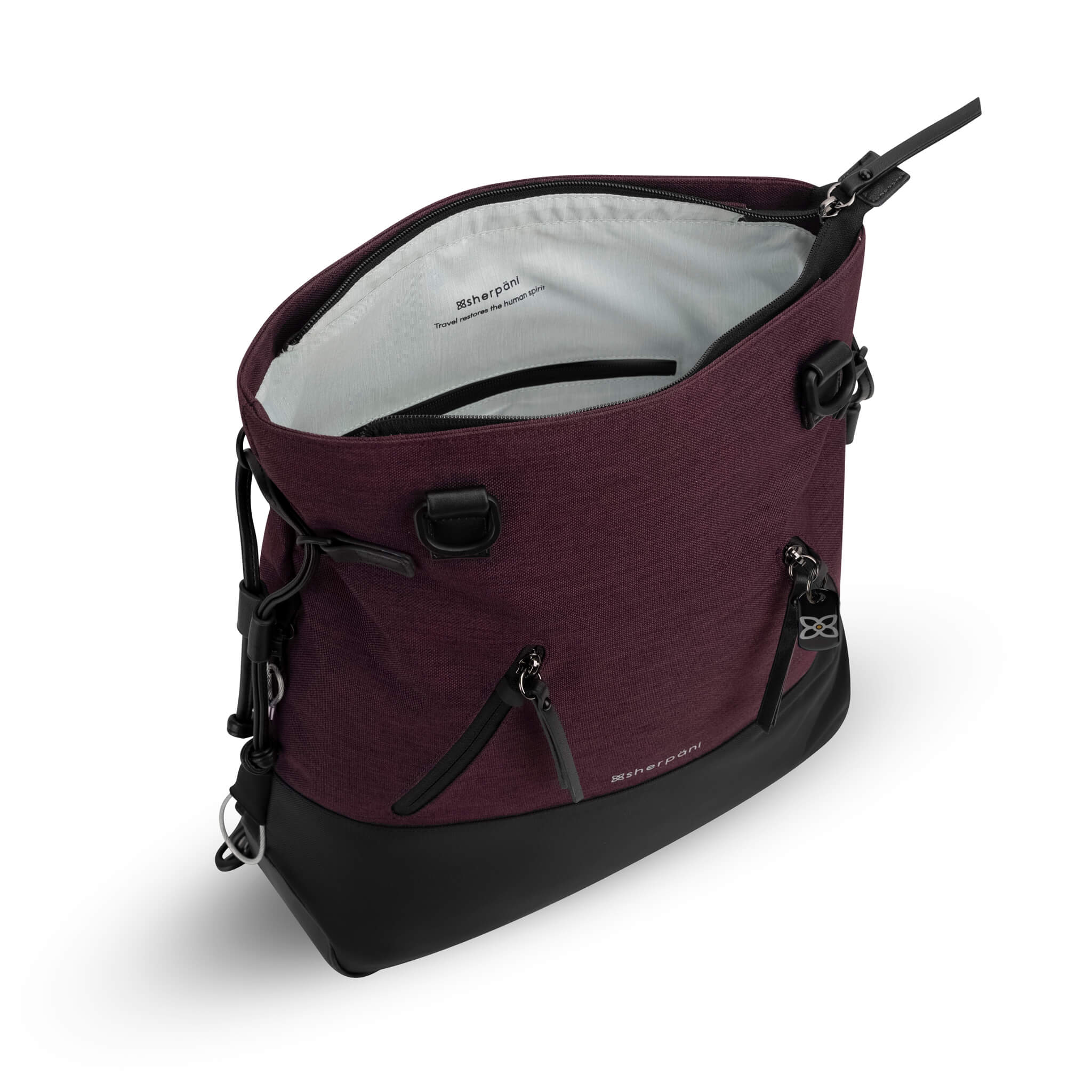 Inside view of Sherpani Anti-Theft backpack tote, the Tempest in Merlot. The main compartment is open to reveal Sherpani logo and the words "Travel restores the human spirit" printed on the light gray interior. 
