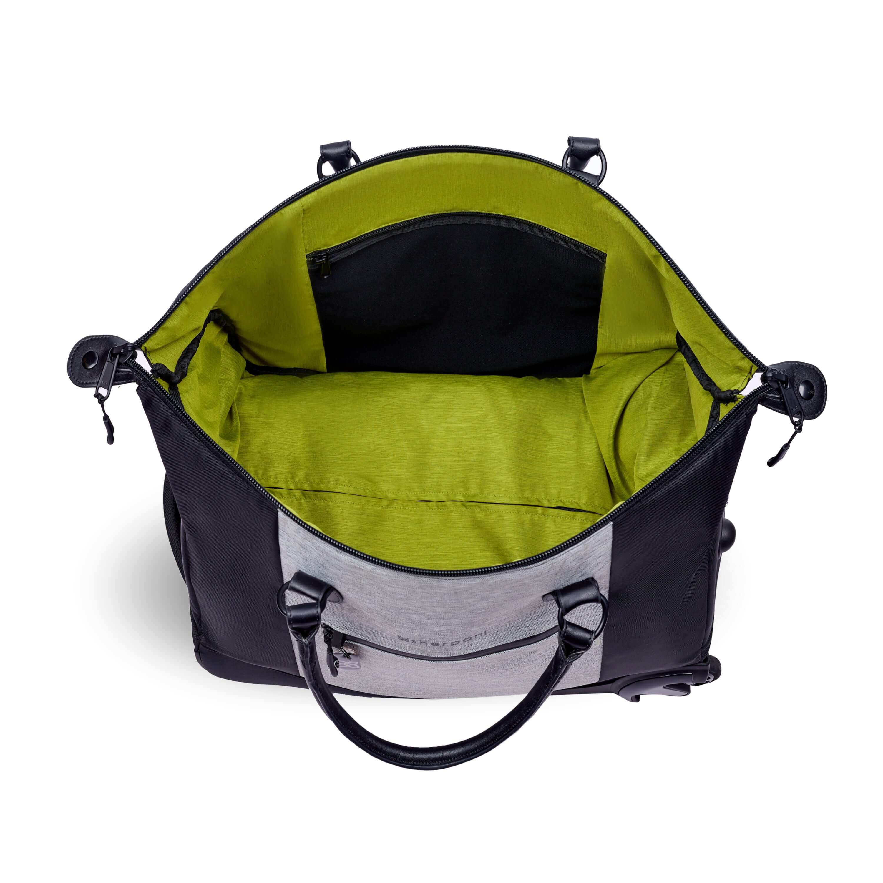 Top view of Sherpani’s Anti-Theft rolling duffle the Trip in Sterling. The main zipper compartment is open showcasing a wide mouth and revealing a lime green interior with an internal zipper pocket. 