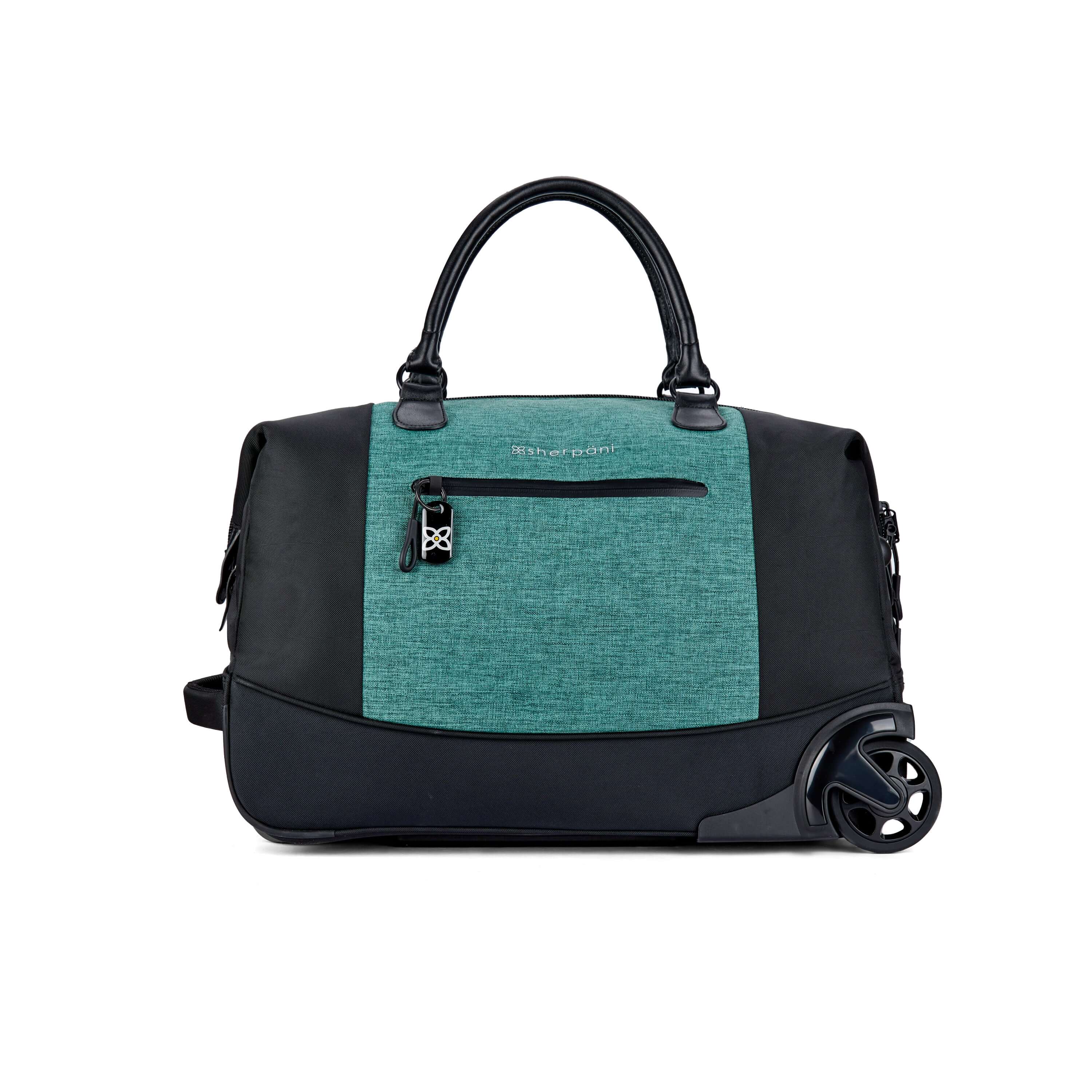 Flat front view of Sherpani’s Anti Theft rolling Duffle, the Trip in Teal, with vegan leather accents in black. The bag lies flat on the ground with a retractable luggage handle hidden on the left side and the rolling wheels shown on the right side. The bag features short tote handles at the top and an external zipper compartment on the front panel with locking zipper and ReturnMe tag. 