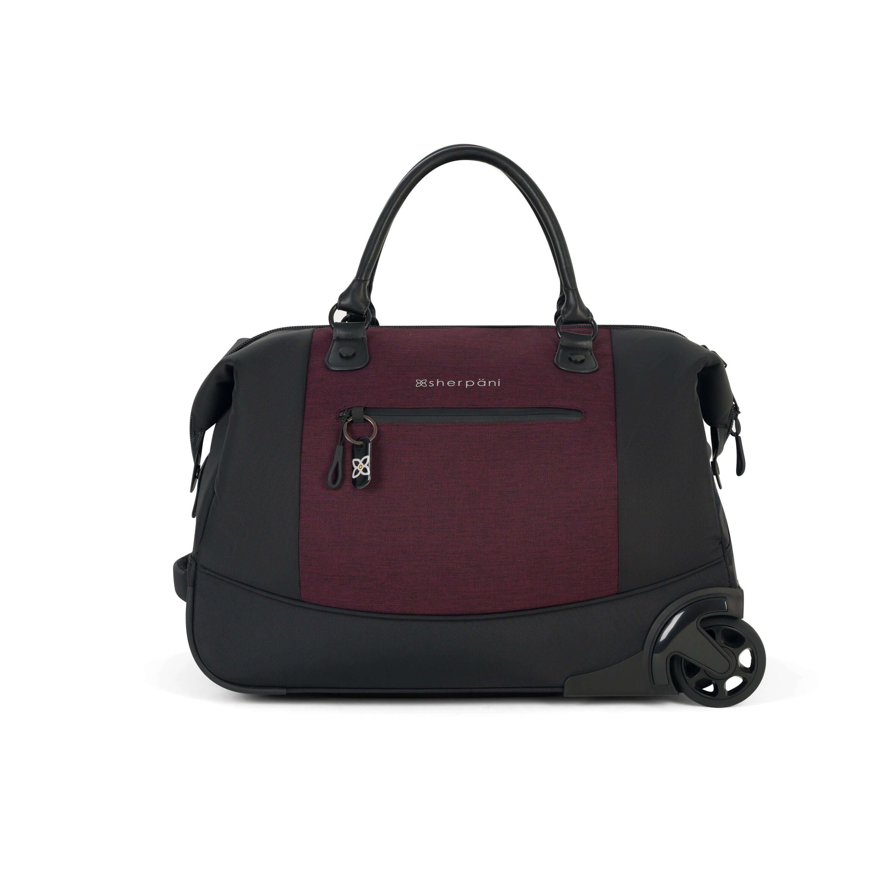 Flat front view of Sherpani’s Anti Theft rolling Duffle, the Trip in Merlot, with vegan leather accents in black. The bag lies flat on the ground with a retractable luggage handle hidden on the left side and the rolling wheels shown on the right side. The bag features short tote handles at the top and an external zipper compartment on the front panel with locking zipper and ReturnMe tag. 