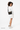 A model smling over her right shouder, wearing the Sherpani's crossbody, the Zoom in Chromatic. #color_chromatic