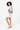 A model smling over her left shouder, wearing the Sherpani's crossbody, the Zoom in Magnolia. #color_magnolia