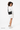 A model smling over her right shouder, wearing the Sherpani's crossbody, the Zoom in Raven. #color_raven