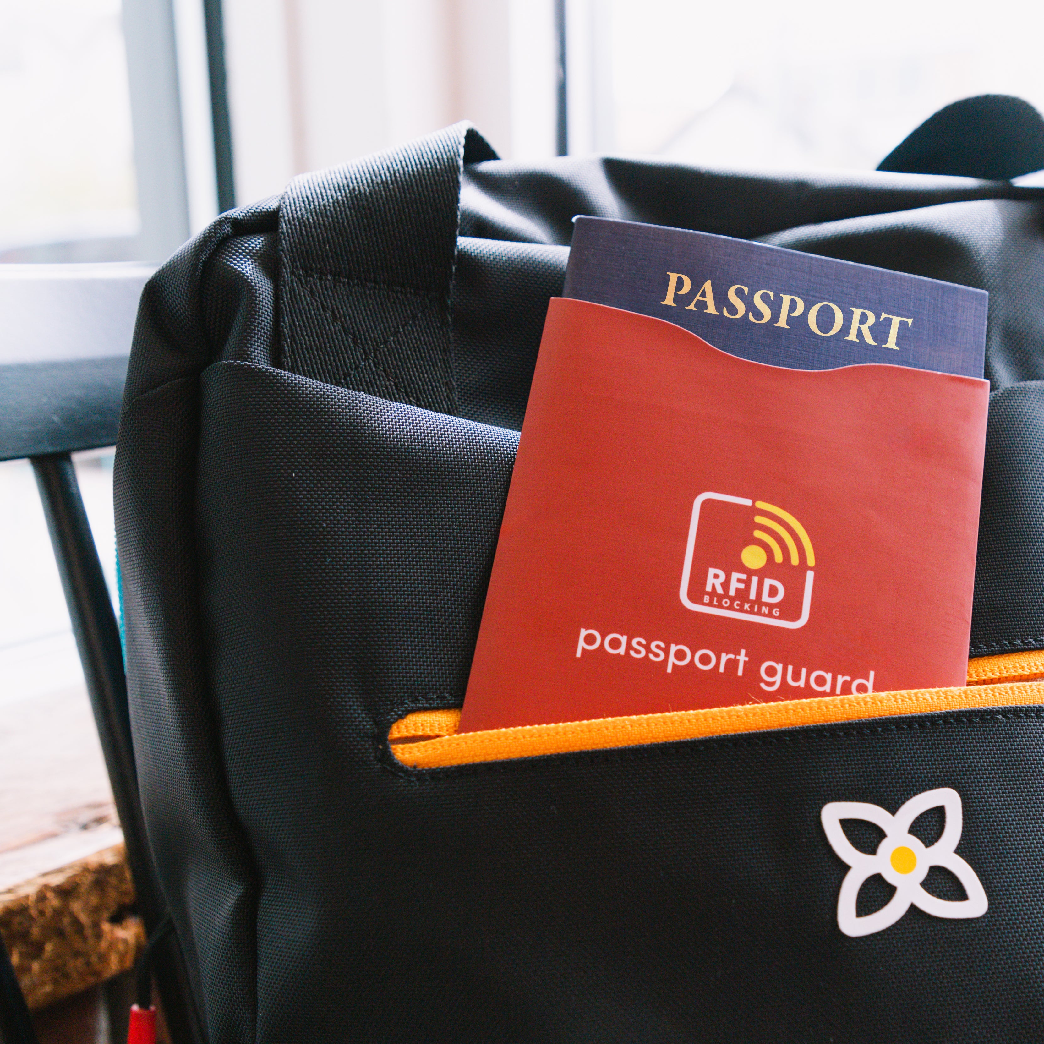 The Passport Sleeve holding a passport and peeking out of the front pocket of a Sherpani travel bag. #color_cider