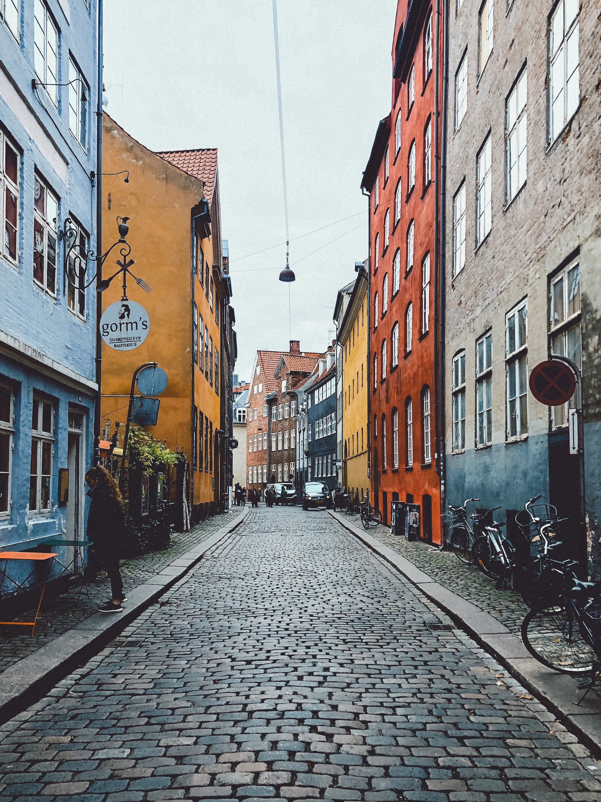 A cobblestone street with colorful buildings in Copenhagen, Denmark.