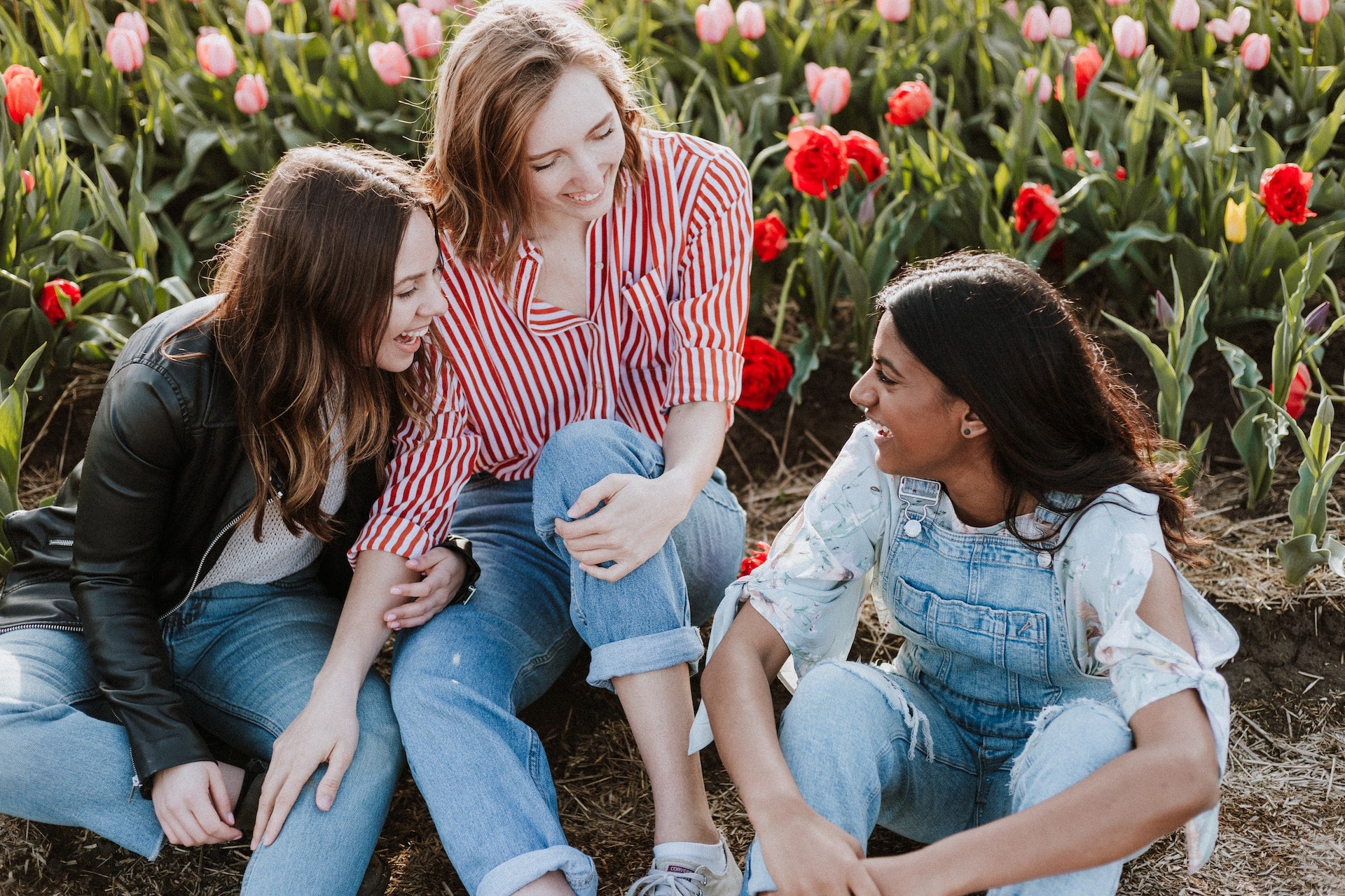 Female friends laughing in a garden of tulips