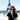 A black woman stands smiles at the camera with the Eiffel Tower behind her