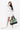 Model holding the Sherpani Boston AT in Basil by its top handle in her left hand. #color_basil