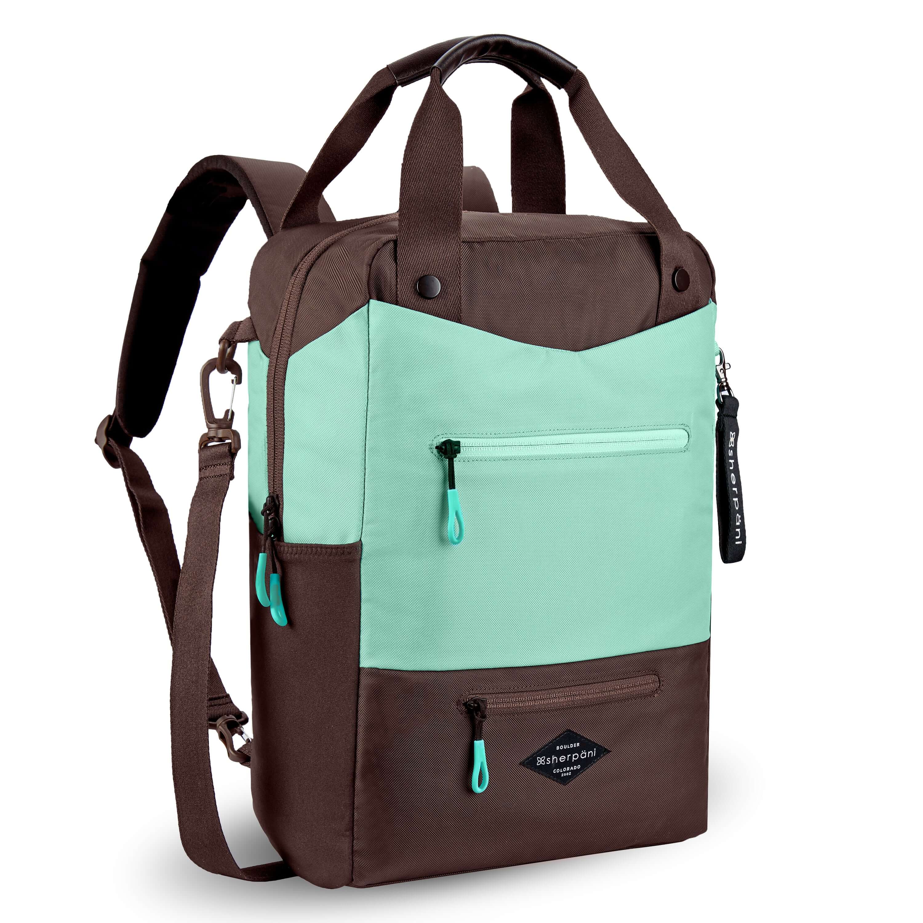 Angled front view of Sherpani&#39;s three-in-one bag, the Camden in Seagreen. The bag is two-toned in light green and brown. There are two external zipper pockets on the front panel with easy-pull zippers in light green. A branded Sherpani keychain is clipped to the upper right corner. An elastic water bottle holder sits on either side of the bag. The bag has an adjustable/detachable crossbody strap, padded/adjustable backpack straps and short tote handles fixed at the top.