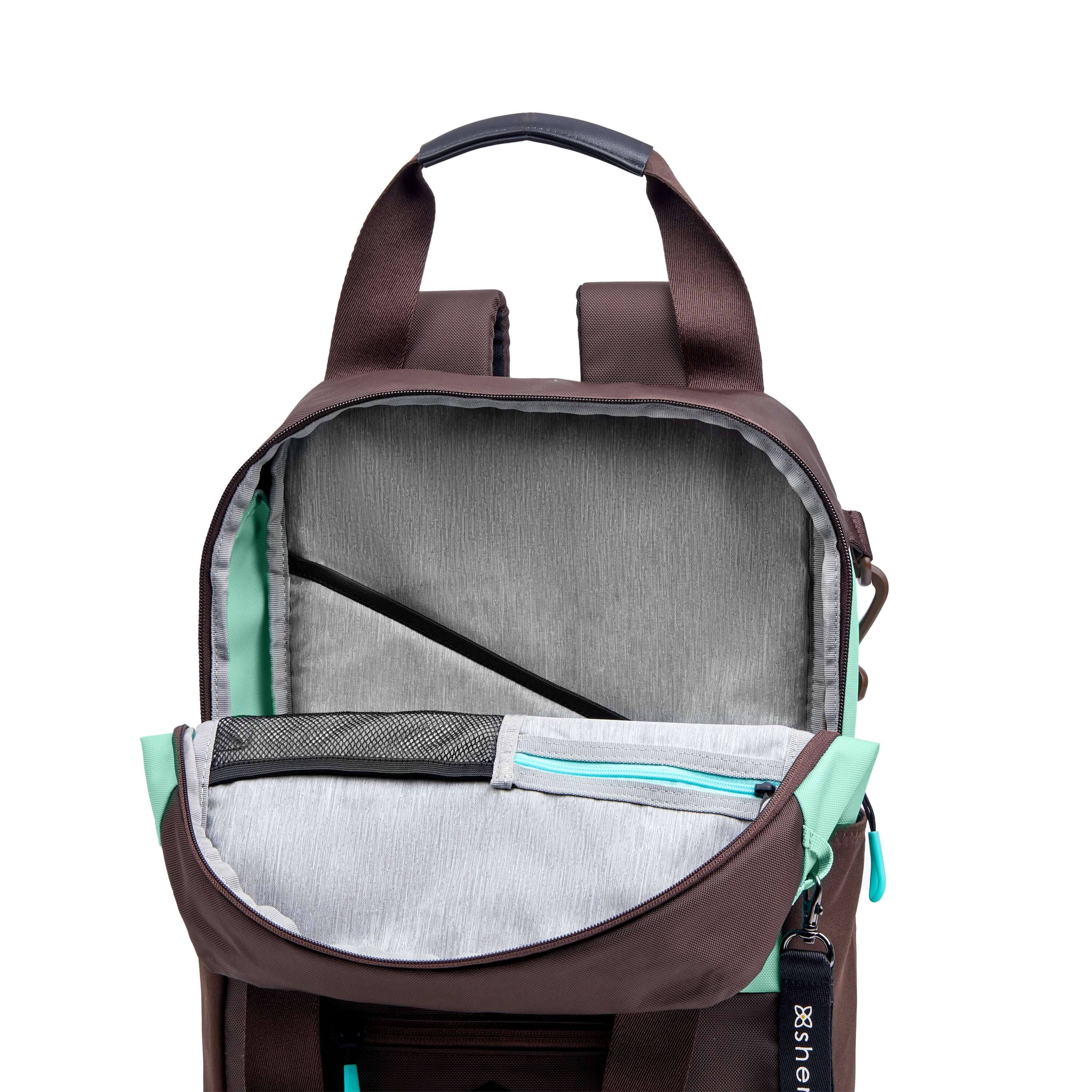 Front view of Sherpani's three-in-one bag, the Camden in Seagreen. The main zipper compartment is open to reveal a light gray interior with a padded laptop sleeve, zipper pocket and mesh pocket. 