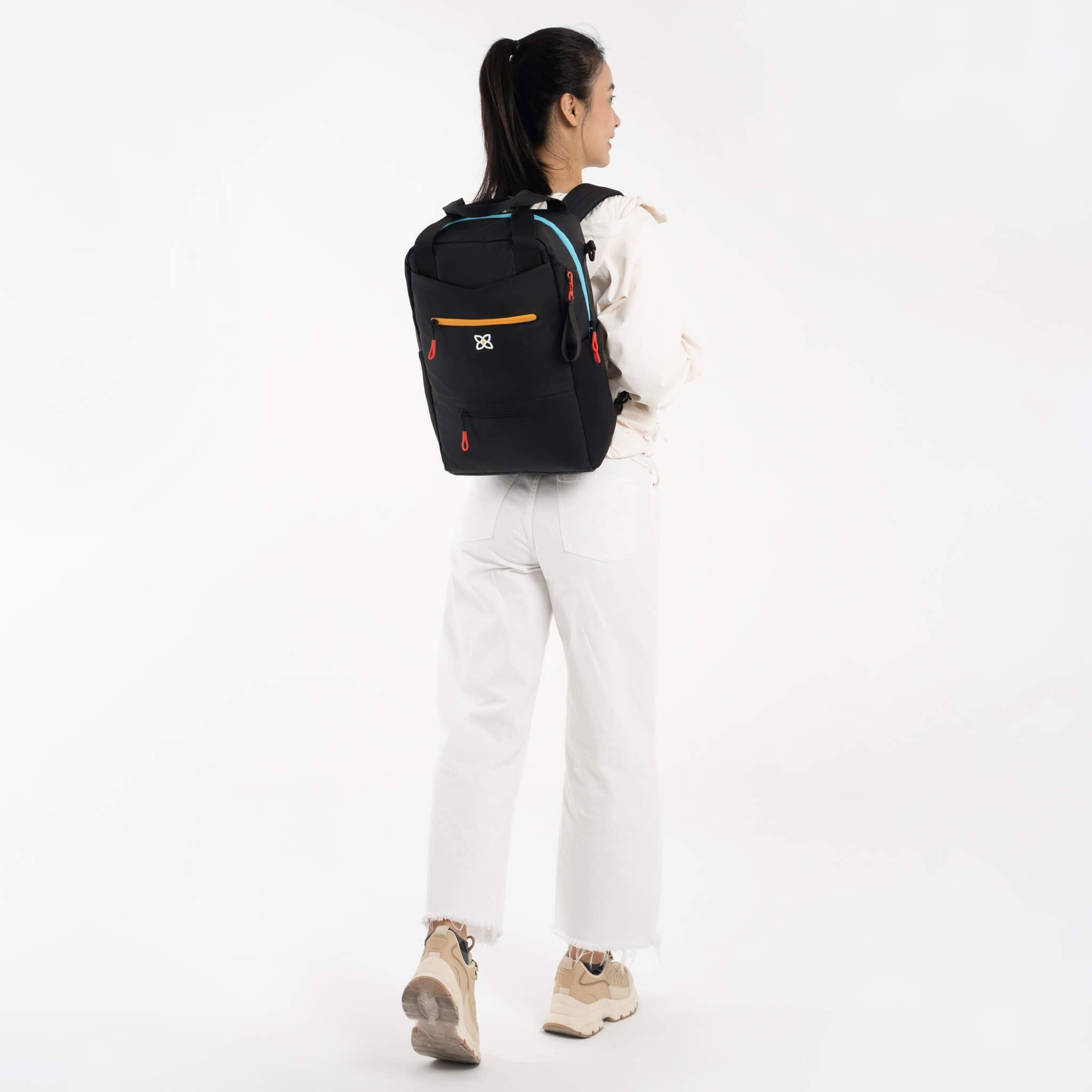 A model wearing Sherpani 3-in-1 tote bag, the Camden in Chromatic, as a backpack. 