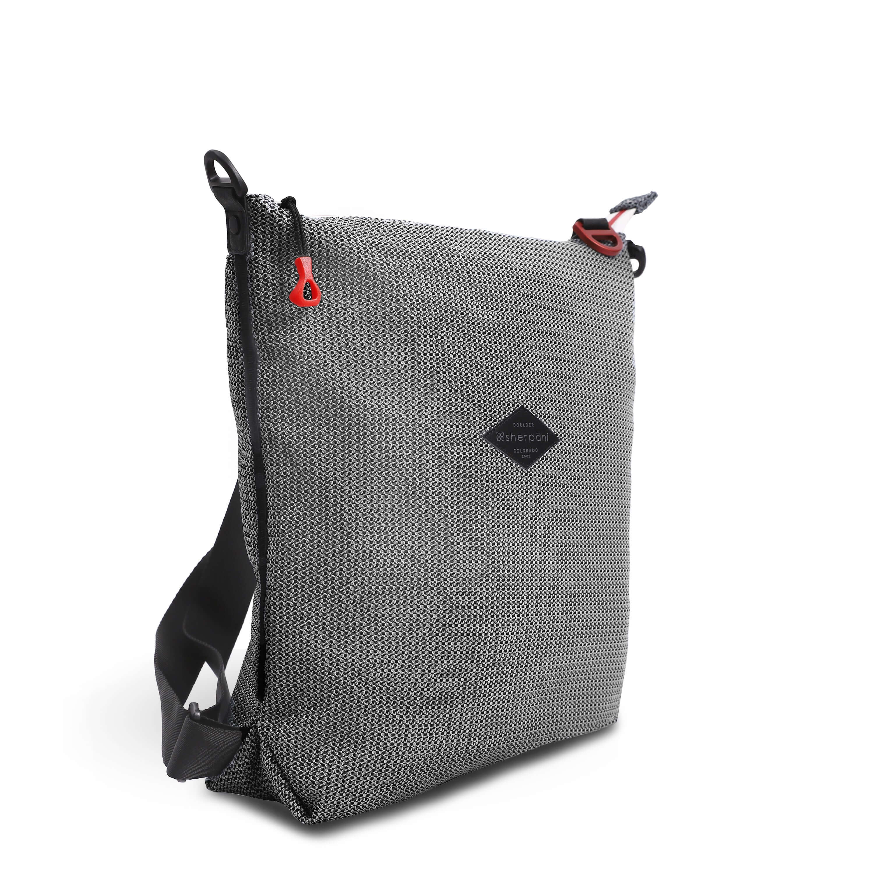 Angled front view of Sherpani convertible mesh bag, the Delanie. It has a black and white mesh pattern and features pops of red on the accent buckle and easy-pull zipper. The bag has adjustable backpack straps and an adjustable/detachable crossbody strap.