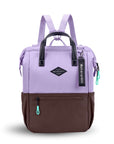 Flat front view of Sherpani three-in-one bag, the Dispatch in Lavender. The bag is two-toned: the top is lavender and the bottom is brown. There is an external zipper pocket on the front panel. Easy-pull zippers are accented in aqua. A branded Sherpani keychain is clipped to the upper right corner. Elastic water bottle holders sit on either side of the bag. It has short tote handles and adjustable/detachable straps that can function for a backpack or crossbody.