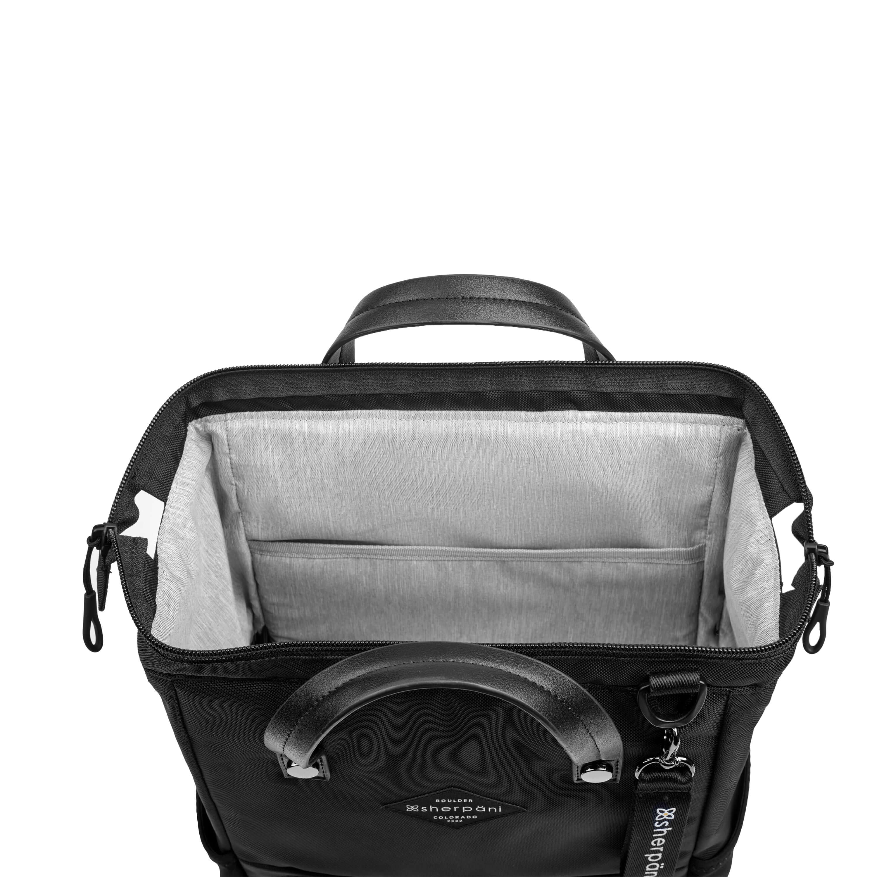 Top view of Sherpani three-in-one bag, the Dispatch in Raven. The main zipper compartment is open to reveal a doctor bag style opening with a rectangular metal frame. The inside of the bag is light gray and features an internal pouch.