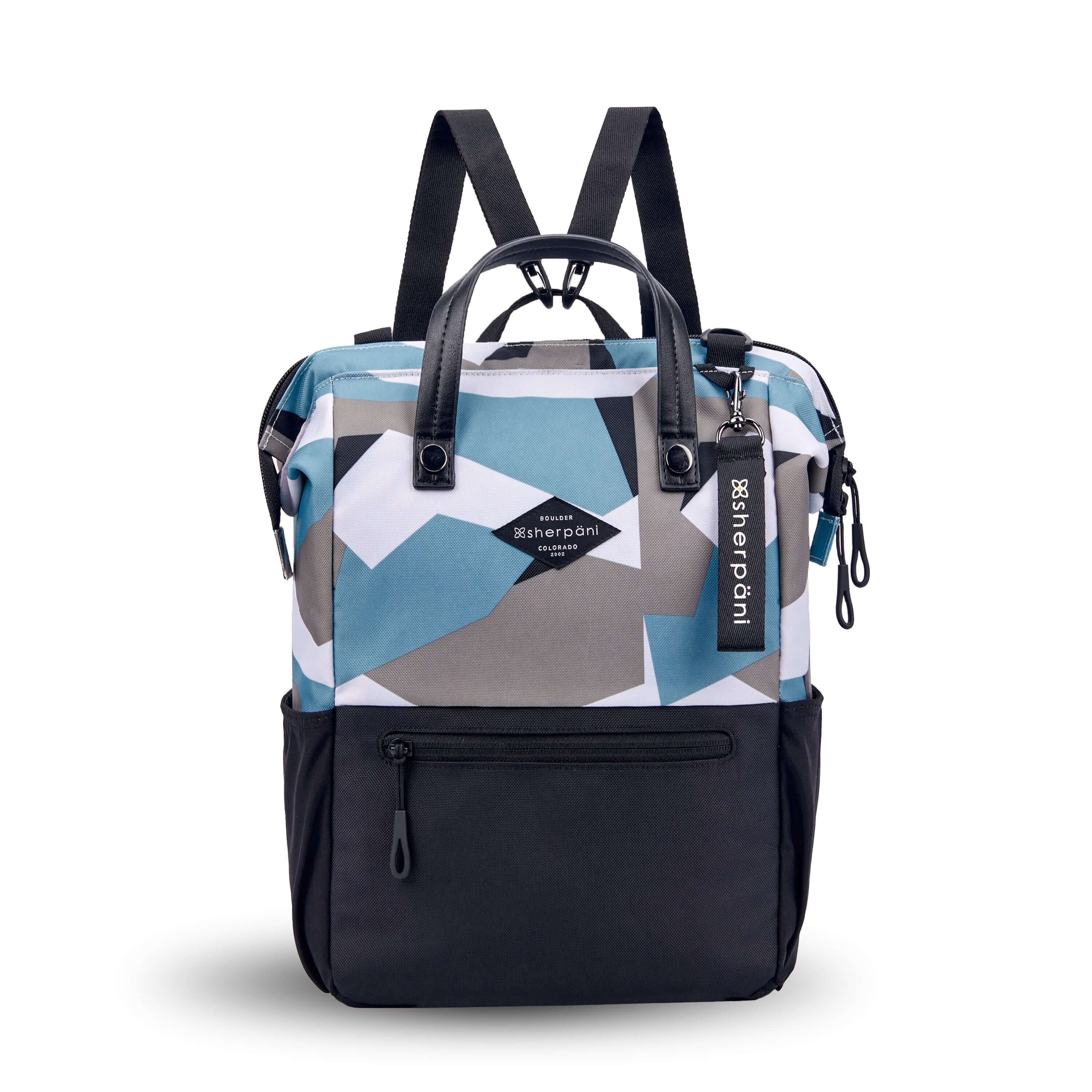 Flat front view of Sherpani three-in-one bag, the Dispatch in Summer Camo. The bag is two-toned: the top is a camouflage pattern of light blue, gray and white, the bottom is black. There is an external zipper pocket on the front panel. Easy-pull zippers are accented in black. A branded Sherpani keychain is clipped to the upper right corner. Water bottle holders sit on either side of the bag. It has short tote handles and adjustable straps that can function for a backpack or crossbody. 