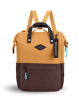 Flat front view of Sherpani three-in-one bag, the Dispatch in Sundial. The bag is two-toned: the top is burnt yellow and the bottom is brown. There is an external zipper pocket on the front panel. Easy-pull zippers are accented in aqua. A branded Sherpani keychain is clipped to the upper right corner. Elastic water bottle holders sit on either side of the bag. It has short tote handles and adjustable/detachable straps that can function for a backpack or crossbody.
