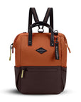 Flat front view of Sherpani three-in-one bag, the Dispatch in Clay. The bag is two-toned: the top is orange and the bottom is brown. There is an external zipper pocket on the front panel. Easy-pull zippers are accented in lime green. A branded Sherpani keychain is clipped to the upper right corner. Elastic water bottle holders sit on either side of the bag. It has short tote handles and adjustable/detachable straps that can function for a backpack or crossbody.