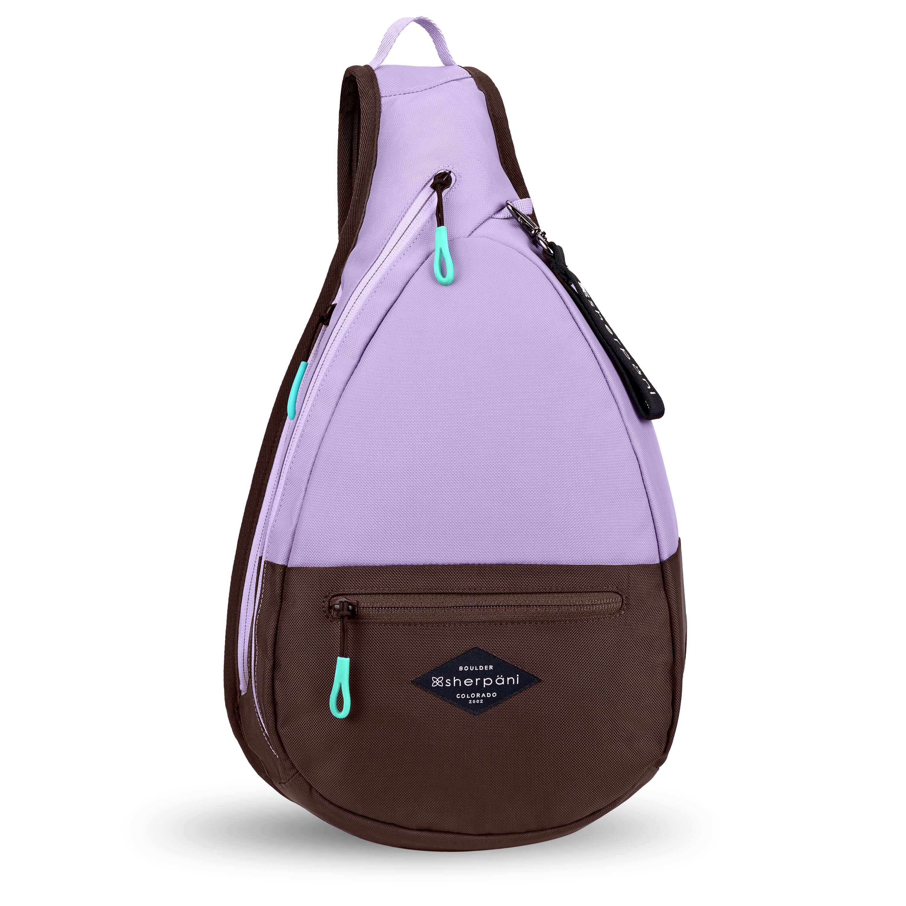 Flat front view of Sherpani's bag, the Esprit in Lavender. The teardrop shaped bag is two-toned in lavender and brown. There is a small zipper pocket on the front of the bag, the main zipper compartment in the middle, and another zipper pocket towards the back of the bag. It has easy-pull zippers accented in aqua. A branded Sherpani keychain is clipped to a fabric loop near the top of the bag. 
