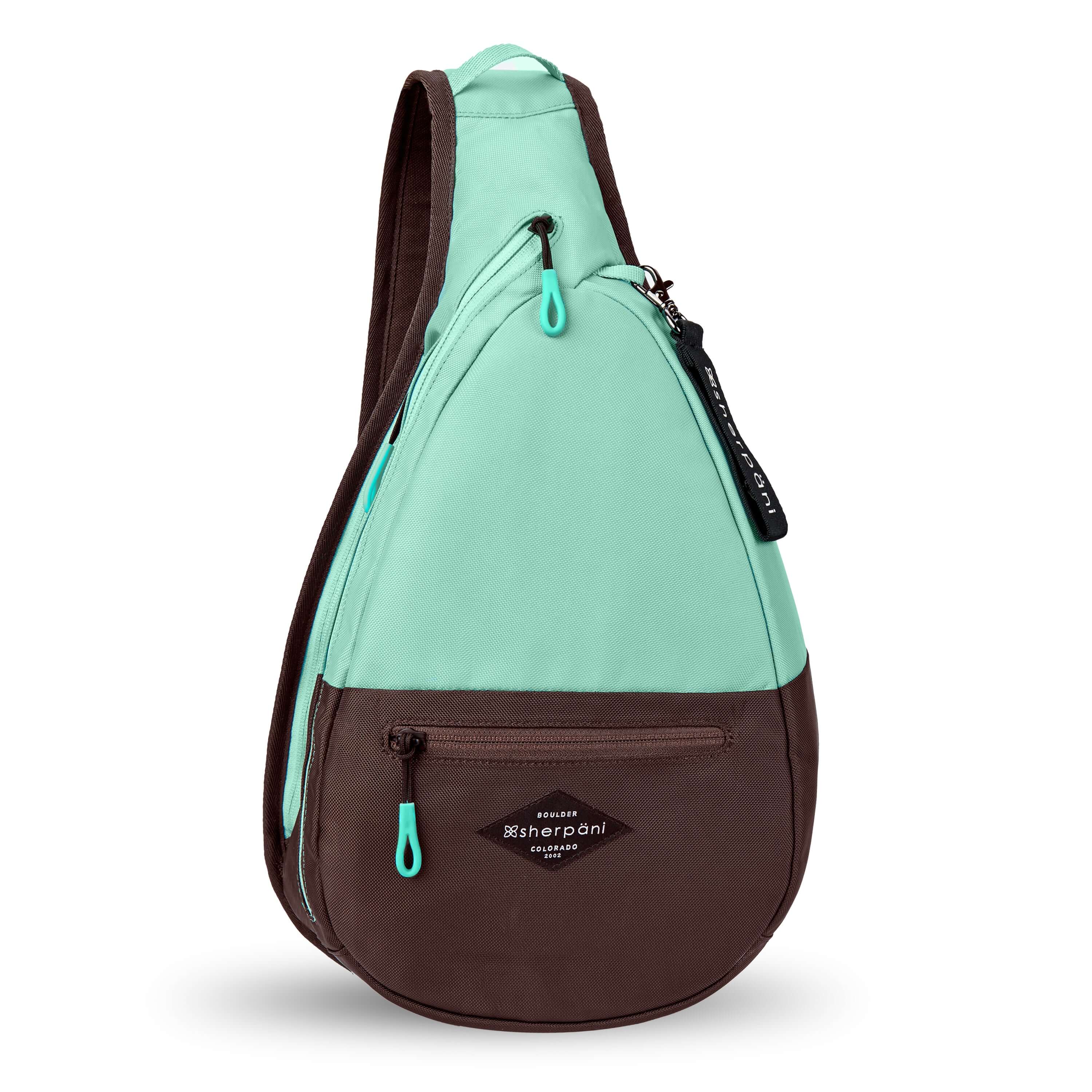 Flat front view of Sherpani's bag, the Esprit in Seagreen. The teardrop shaped bag is two-toned in light green and brown. There is a small zipper pocket on the front of the bag, the main zipper compartment in the middle, and another zipper pocket towards the back of the bag. It has easy-pull zippers accented in light green. A branded Sherpani keychain is clipped to a fabric loop near the top of the bag. 