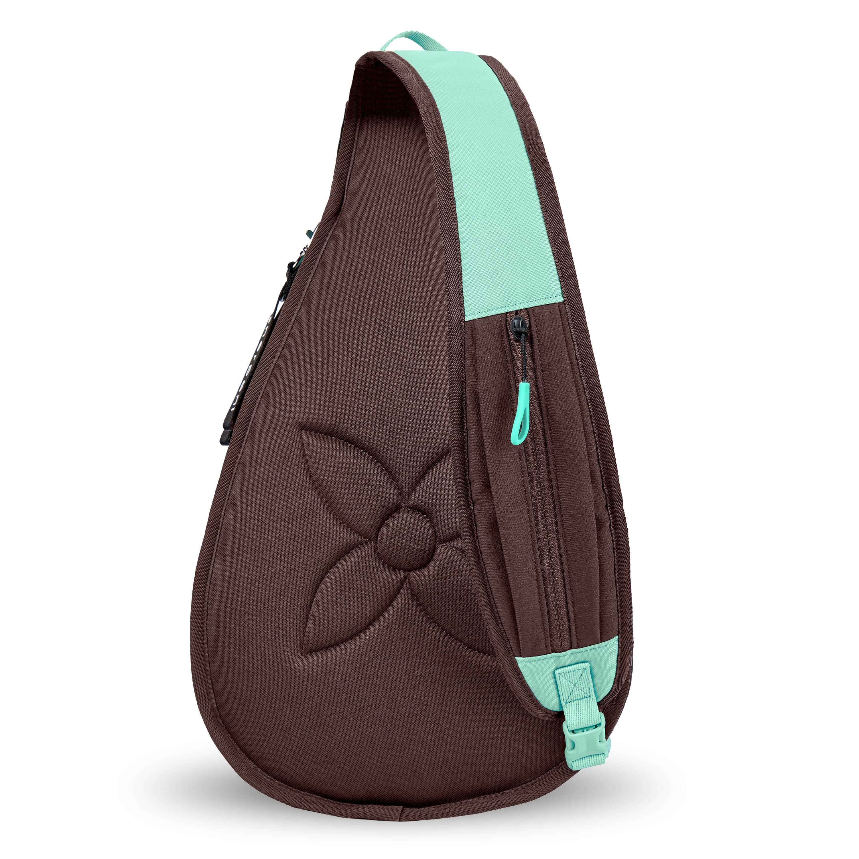 Back view of Sherpani's bag, the Esprit in Seagreen. There is a large edelweiss stitched into fabric. The crossbody strap features a small zipper compartment and a buckle for ease. 