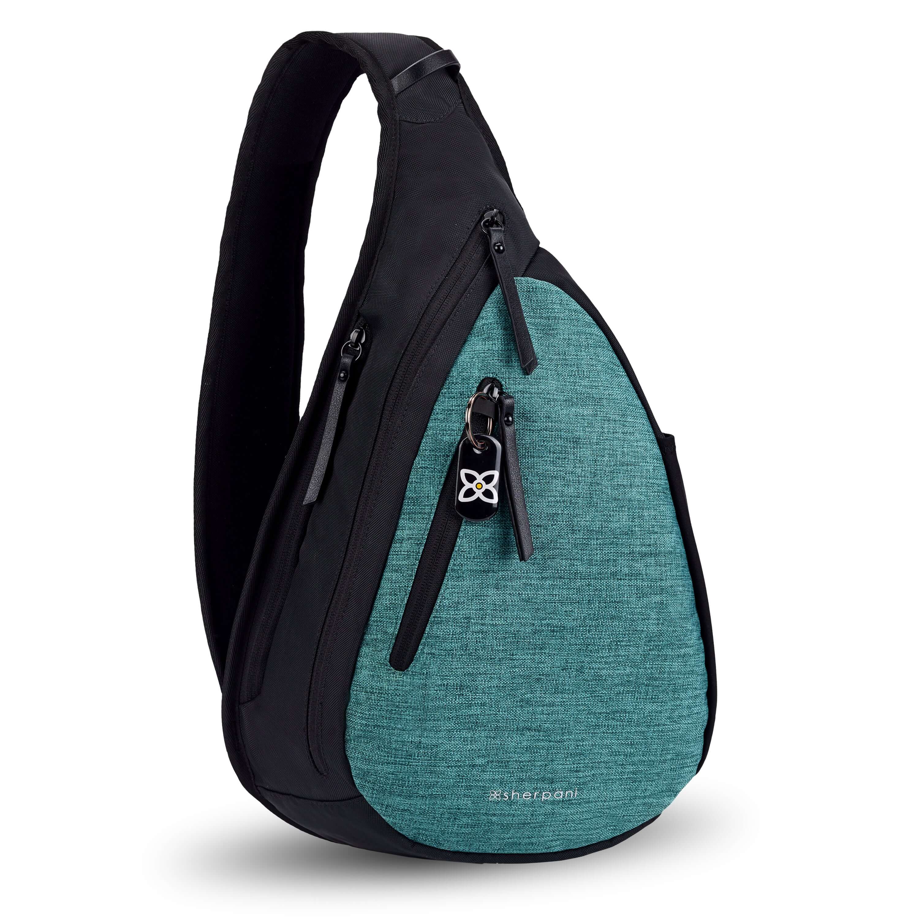 Angled front view of Sherpani's Anti-Theft bag, the Esprit AT in Teal, with vegan leather accents in black. There is a locking zipper compartment on the front, and two more zipper compartments on the side. An elastic water bottle holder sits on the other side of the bag.