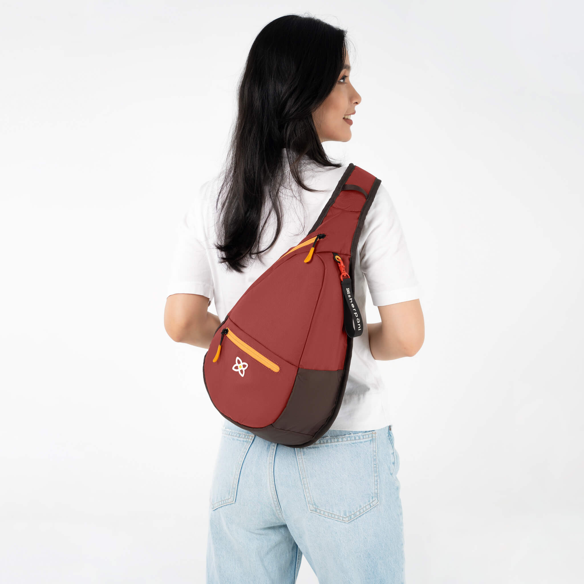 A model showing Sherpani travel sling backpack, the Esprit in Cider.