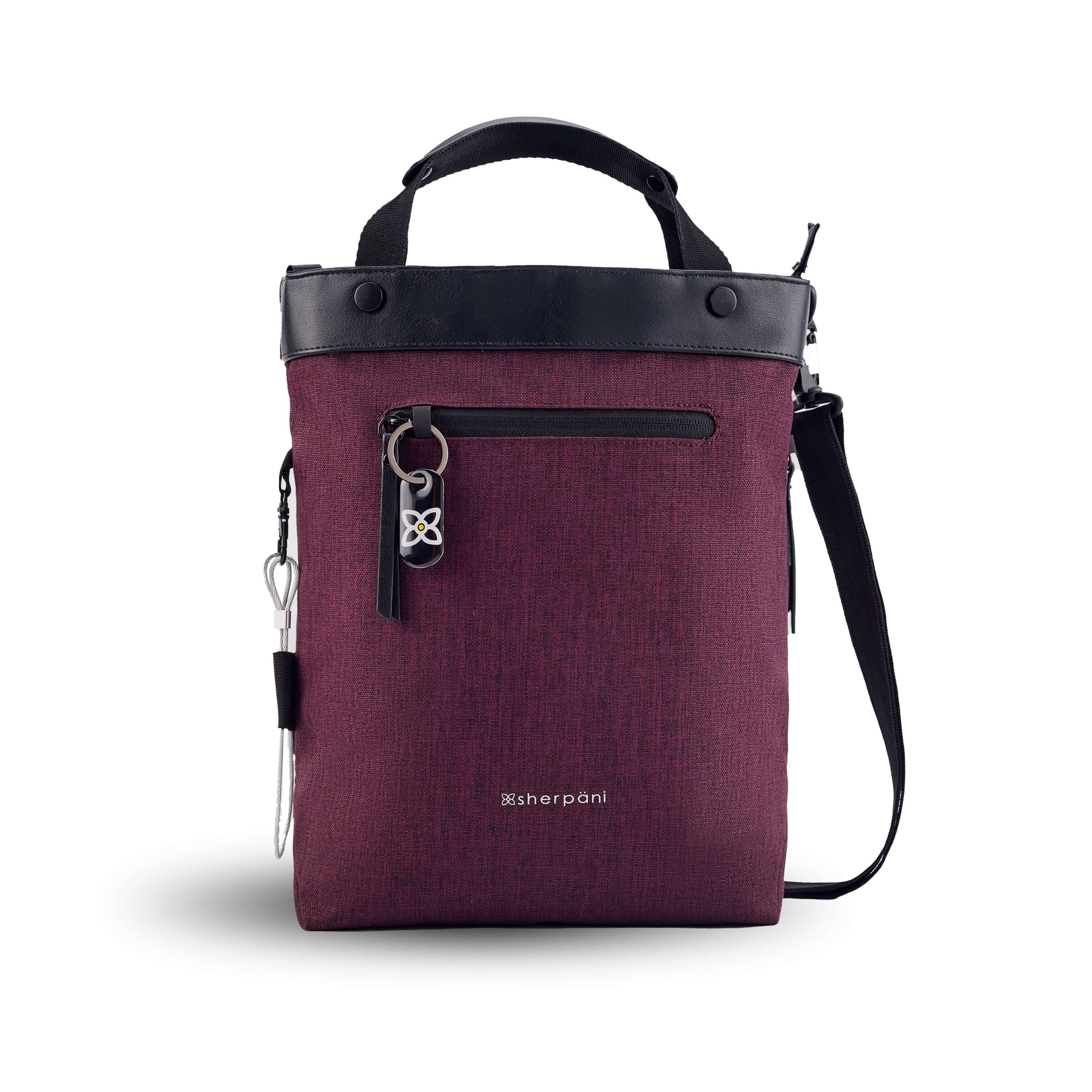 Flat front view of Sherpani&#39;s Anti-Theft bag, the Geo AT in Merlot, with vegan leather accents in black. The bag features short tote handles and an adjustable/detachable crossbody strap. There is a locking zipper compartment on the front with a ReturnMe tag. A chair loop lock is clipped to the side and secured in place by an elastic tab.