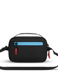 Back view of Sherpani's fanny pack, the Hyk in Chromatic. The back of the bag is black with a blue accent. Easy-pull zippers are accented in red. The fanny pack features an adjustable strap with a buckle.