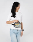 A model showing Sherpani travel fanny pack, the Hyk in Fiori, as a hip pack.