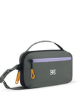Angled front view of Sherpani hip pack, the Hyk in Juniper. Hyk features include an adjustable waist strap, two external zipper pockets, an internal zipper pocket and RFID-blocking technology to block cyber theft. The Juniper color is gray with yellow and purple accents.
